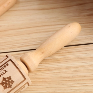 Macro detail of Jolly snowflake engraving on natural wood Christmas rolling pin
