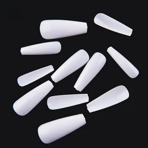 Close-up of white coffin press-on nails in various sizes with size numbers on black background