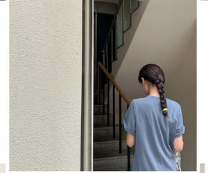 Detail of yellow nylon hair tie on hair model wearing a blue casual t-shirt