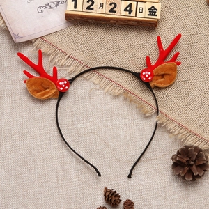 Close-up of Christmas reindeer antler headband on rustic burlap with pine cones