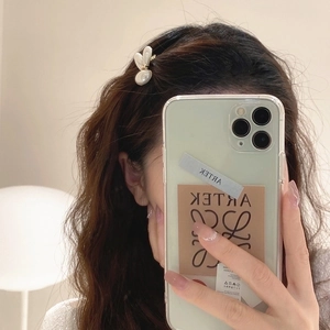 Elegant white pearl rabbit hair clip worn by a woman with a side profile view