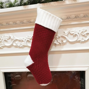 Close-up of cable knit Christmas stocking with hanging loop on white mantel fireplace