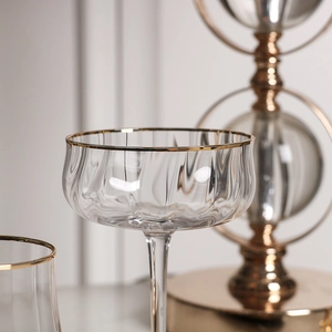Luminous tulip champagne glass with gold rim and ribbed texture in elegant setting