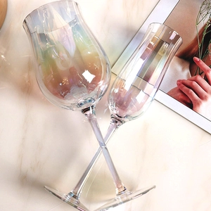 Iridescent crystal wine and tulip cocktail glasses on marble background lifestyle set