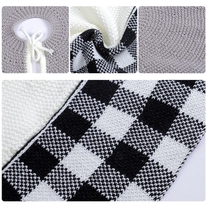 Detail of knitted Christmas tree skirt with black and white checkered pattern and tie closure