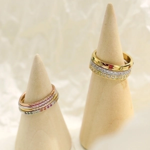 Minimalist titanium steel rings with micro-set zircon on wooden cone displays
