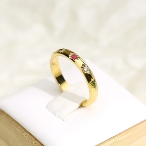 Detailed view of gold plated titanium steel ring with colorful inlaid stones and starbursts