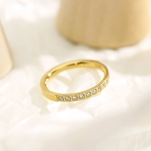 Detail of slim gold titanium steel ring featuring hollowed design and sparkling pavé diamonds