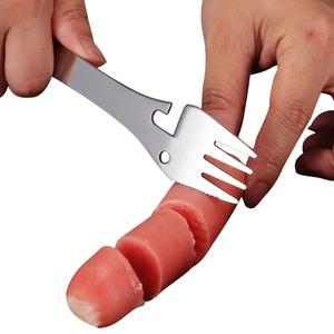 5-in-1 stainless steel camping utensil used for cutting sausage on a white background