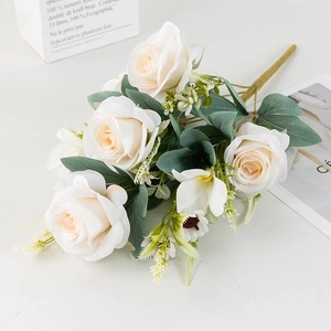 Detail of faux white roses bouquet with green leaves and realistic silk petals