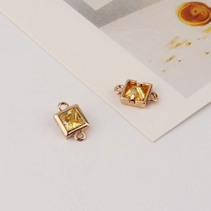 Macro view of gold-plated square zircon connectors with yellow gemstones for DIY jewelry