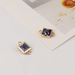 Detail of square gold-plated pendants with blue zircon crystals for DIY jewelry making