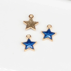 Detailed view of star-shaped charms with blue enamel and gold finish for DIY jewelry