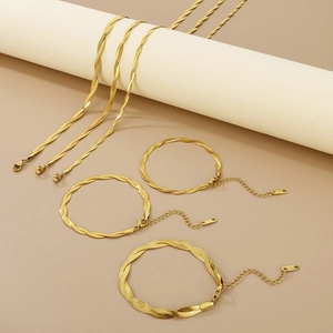 Detailed set of golden flat snake and twisted rope chains on minimalist display