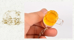 Makroansicht des Mini-Bierkrug-Schlüsselanhängers mit Schaum und Metall-Schlüsselring