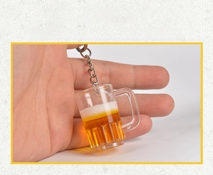 Nahaufnahme eines kreativen Bierkrug-Schlüsselanhängers mit Schaum und gelber Flüssigkeit