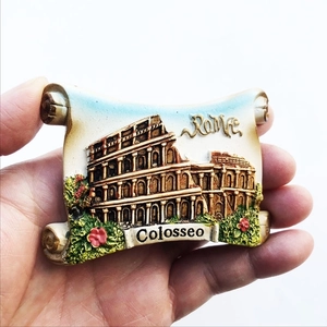 Close-up of a resin Rome Colosseum souvenir fridge magnet with hand holding it