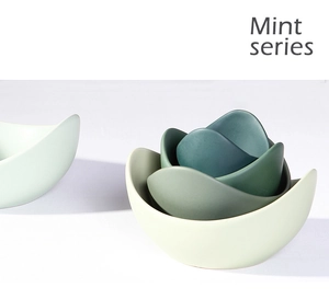 Detail of stacked lotus-shaped ceramic bowls in mint green matte finish for home decor