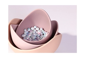 Detail of matte ceramic lotus bowls nested with colorful decorative pearls inside
