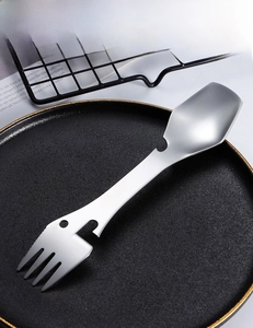 Close-up of 5-in-1 stainless steel camping spork with opener on a black plate