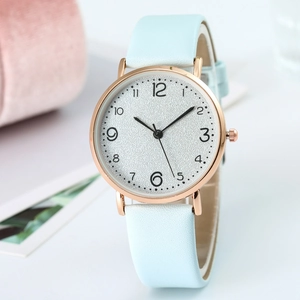 Close-up of a slim rose gold quartz watch featuring a light blue leather strap and white dial