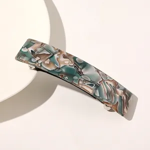 Vue détaillée d'une barrette en acétate à motif marbré vert avec pince à ressort argentée