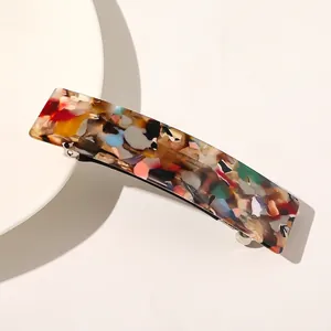 Gros plan sur la pince à cheveux carrée en acétate avec motif mosaïque coloré