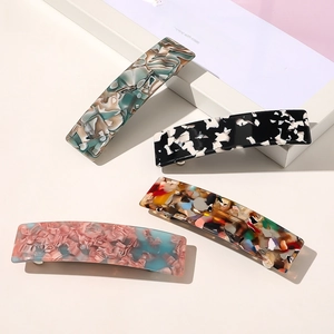 Détail macro de pinces à cheveux rectangulaires en acétate aux motifs marbrés et écaille