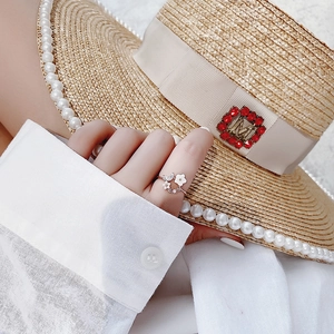 Close-up of rose gold flower ring with sparkling crystals and pearls on hand