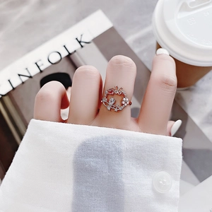 Macro detail of rose gold flower ring with sparkling crystals against lifestyle background