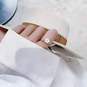 Close-up of white flower ring with zircon details worn during a summer vacation