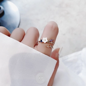 Detailed close-up of a flower ring featuring white petals and purple zircon stones