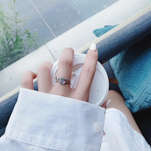 Close-up of double-layer silver ring with blue stone and star zircon on hand