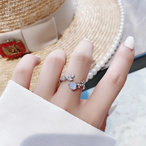 Detailed view of silver adjustable ring with blue heart stone and white zircon petals