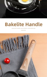Detail of ergonomic wood-grain bakelite handle with hanging hole on non-stick egg frying pan