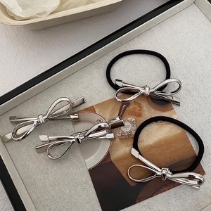 Silver metal bow hair clip and elastic hair tie set with a polished mirror finish