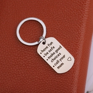 Silver keychain with Have Fun Be Safe engraved tag on premium brown leather background