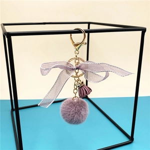 Detail of purple faux fur pompom keychain with chiffon bow and gold-plated lobster clasp