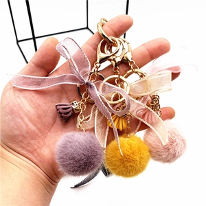 Plush ball bow keychains in purple yellow and pink with gold lobster clasps and lace