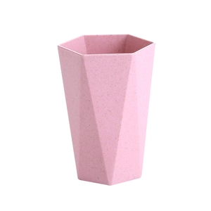Pink hexagonal geometric mouthwash cup made of wheat straw plastic on white background