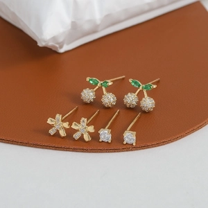 Macro shot of three pairs of S925 silver stud earrings featuring cherry and flower designs