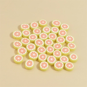 Close-up of 10mm yellow polymer clay beads with orange fruit slices for DIY jewelry