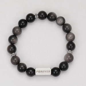 Close-up of black obsidian beads and silver metal plate engraved with FOREVER