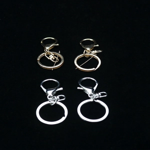 Detail of silver and gold lobster clasps and key rings on black velvet background