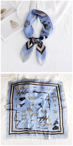 Detailed view of sky blue equestrian print silk scarf with golden buckles and leather straps