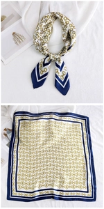 Detail of silk square scarf featuring gold horsebit chain print and navy blue borders
