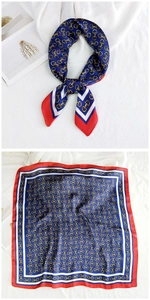 Close-up of silk scarf with golden chain patterns and red blue border details