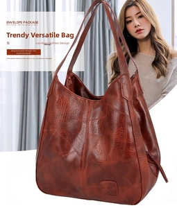 Close-up of vintage brown leather tote bag with patchwork design and logo detail