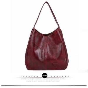 Detailed view of dark red soft leather tote bag featuring irregular geometric stitching pattern