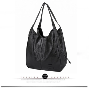 Close-up of black litchi pattern hobo bag showing premium synthetic leather and brand tag